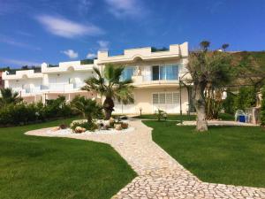 ein großes weißes Gebäude mit Palmen und einem Gehweg in der Unterkunft Villa sul Mare in Belvedere Marittimo