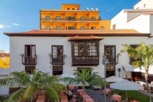 ein Hotel mit Tischen und Stühlen vor einem Gebäude in der Unterkunft Hotel Marquesa in Puerto de la Cruz