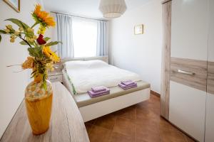 a bedroom with a bed and a table with a vase of flowers at Apartament Augustów in Augustów