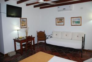 sala de estar con cama, escritorio y TV en Hostería Posada del Sol, en Libertador General San Martín