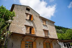 an old brick building with shuttered windows at B&b L' Arancio in fiore in Sant'Agnello