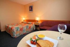 una camera d'albergo con tavolo e piatto di cibo di Heemskirk Motor Hotel a Zeehan