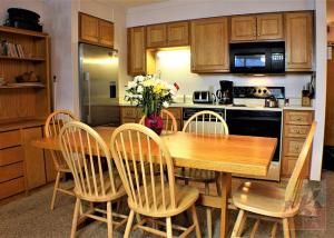 una cocina con una mesa de madera con sillas y un asterisco en Great Location 3 bedroom condo, Ski home Whiffletree E8, en Killington