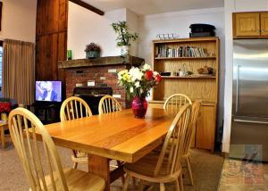 cocina con mesa de madera con sillas y nevera en Great Location 3 bedroom condo, Ski home Whiffletree E8, en Killington