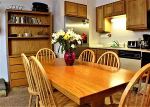 una cocina con una mesa de madera con un jarrón de flores. en Great Location 3 bedroom condo, Ski home Whiffletree E8, en Killington