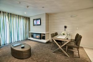 a living room with a table and a fireplace at The St James Premium Accommodation in Hanmer Springs