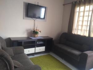 ein Wohnzimmer mit einem Sofa und einem TV in der Unterkunft Casa do Bruno in Olímpia