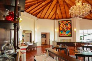una sala da pranzo con tavoli e lampadario pendente di Oak Ray Summer Hill Breeze a Nuwara Eliya
