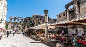 a group of people sitting at tables in an outdoor market at Apartment Vinko in Split