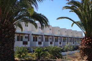 un edificio con palmeras en el primer plano en Aiolos 17, en Puerto Calero