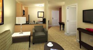 a hotel room with a couch and a chair and a television at Ledgestone Hotel in Yakima