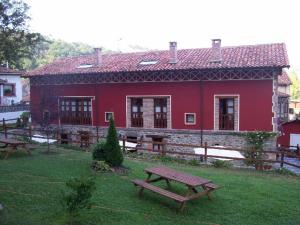 a red building with picnic tables in front of it at La Cocada in Arriondas