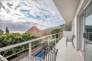 a balcony with chairs and a view of the mountains at 2 on Medburn in Cape Town