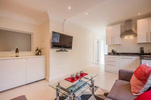 a living room with a couch and a kitchen at 2 on Medburn in Cape Town