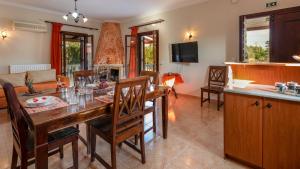 Pothos Villas في مدينة زاكينثوس: مطبخ وغرفة معيشة مع طاولة وكراسي خشبية