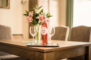 a bottle of wine sitting on a table with two glasses at Suzy Apartman in Eger