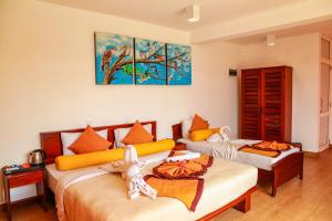 2 letti in una camera con dipinti alle pareti di Oak Ray Summer Hill Breeze a Nuwara Eliya