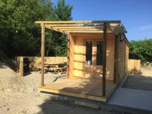 une maison extérieure en bois avec un toit en bois dans l'établissement Romantic Getaway Luxury Wooden Cabin With Private Hot Tub and BBQ, à Aberystwyth