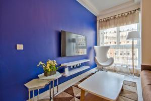 聖朱利安斯的住宿－"Centre Point" Apartment，客厅拥有蓝色的墙壁和白色的椅子