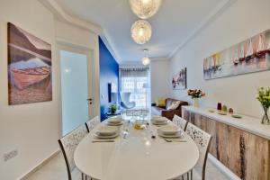 聖朱利安斯的住宿－"Centre Point" Apartment，一间配备有白色桌椅的用餐室