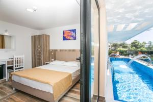 a bedroom with a bed and a swimming pool at Villa Delux in Ulcinj