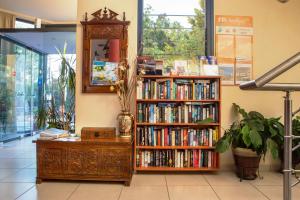 a book shelf filled with books next to a mirror at Aeolian Gaea Hotel in Skala Kallonis