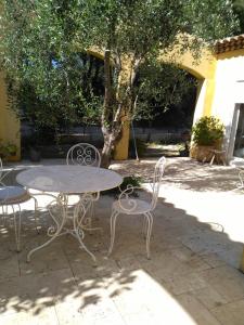 a table and chairs sitting under a tree at Chambres de la Terre Blanche in Sanary-sur-Mer