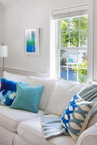 a white couch with blue pillows in a living room at Blue - Inn on the Beach in Newburyport