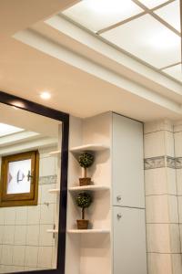 a bathroom with a mirror and two plants on shelves at Maisonette House Minos in Heraklio