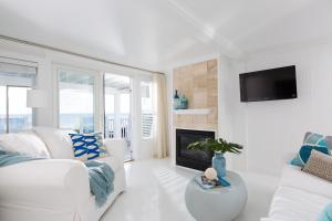 a white living room with a white couch and a fireplace at Blue - Inn on the Beach in Newburyport