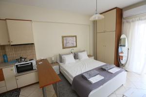 1 dormitorio con cama, mesa y cocina en Studio B1, en Ioannina