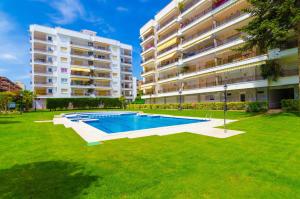 a swimming pool in front of a large apartment building at Alva Park in Lloret de Mar