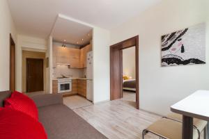 ein Wohnzimmer mit einem roten Sofa und einer Küche in der Unterkunft Lights Apartments with two bedrooms in the center of city in Lwiw
