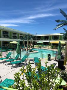 a hotel with a pool with chairs and umbrellas at Caribbean Motel in Wildwood Crest