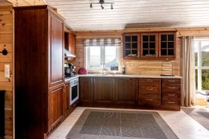 a large kitchen with wooden cabinets and a window at Valley View in Stranda