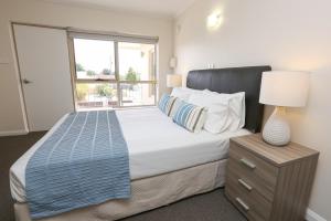 a bedroom with a large bed with a window at Seven Pines Motor Inn in Mildura