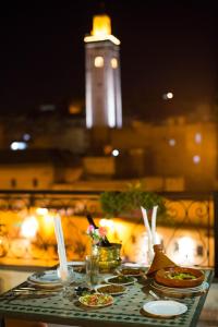 uma mesa com pratos de comida com uma torre ao fundo em Riad Fes Bab Rcif Sid Aowad & spa em Fez
