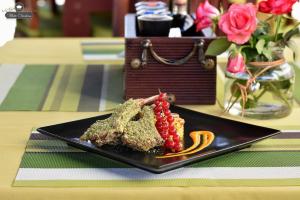 a black plate of food on a table at Boutique Vila White Duchess in Mamaia Nord