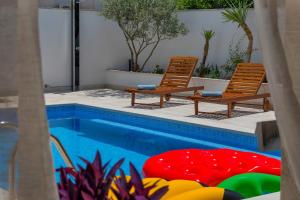 two chairs sitting next to a swimming pool at Apartment Mediteraneo in Makarska