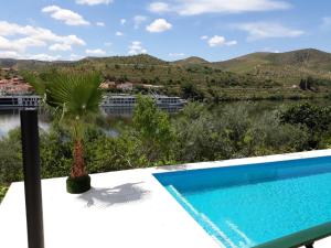 a swimming pool with a view of a river and mountains at Quinta Da Ponte in Barca dʼAlva