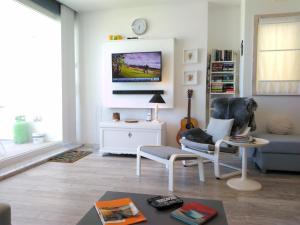 un salon avec un canapé et une télévision sur un mur dans l'établissement R1100ERI Ramla Bay by euroresort, à Ix-Xagħra