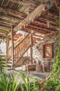 a stone house with a staircase and a table in it at The Dragon Barn - Studio in Ascou