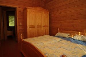 ein Schlafzimmer mit einem Bett in einem Blockhaus in der Unterkunft Blockhaus-Ferienpark in Eisenschmitt