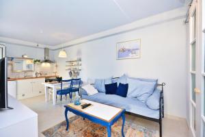 a living room with a blue couch and a table at Apartment Pepica with sea view in Postira