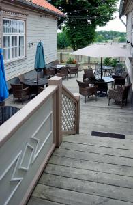 a patio with tables and chairs and an umbrella at Boutique Hotel Virkas muiža in Kuldīga