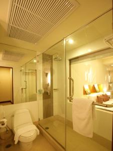 a bathroom with a glass shower and a toilet at Maninarakorn Hotel in Chiang Mai