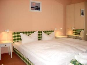 a bedroom with a large white bed with a green headboard at Hotel Neustadt in Osnabrück