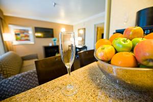 eine Schale Obst auf einem Tisch mit einem Glas in der Unterkunft Hotel d'Lins Ontario Airport in Ontario