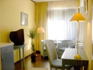 a living room with a table and a dining room at Hotel Neustadt in Osnabrück