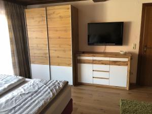 a bedroom with a bed and a flat screen tv at Eva Gutjahr Ferienwohnung in Sankt Gilgen